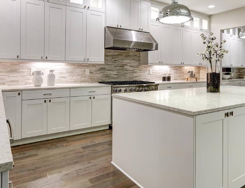 Modern kitchen interior with white cabinetry, marble countertops, and stainless steel appliances Modern kitchen interior with white cabinetry, marble countertops, and stainless steel appliances
