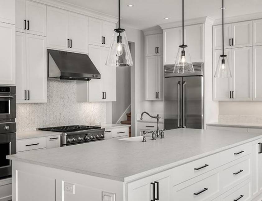 Modern kitchen with white cabinets, stainless steel appliances, and pendant lights Modern kitchen with white cabinets, stainless steel appliances, and pendant lights