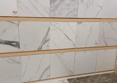 Display of various large marble-effect tiles in a store with price tags