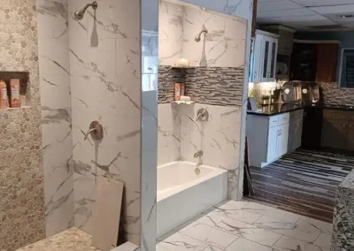 Modern bathroom with glass shower adjacent to a kitchen with wooden cabinets and granite countertops